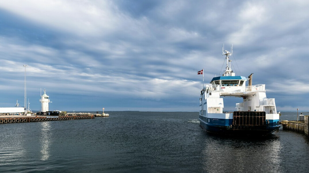 Passengers lined up to board a small ferry in a Danish harbor